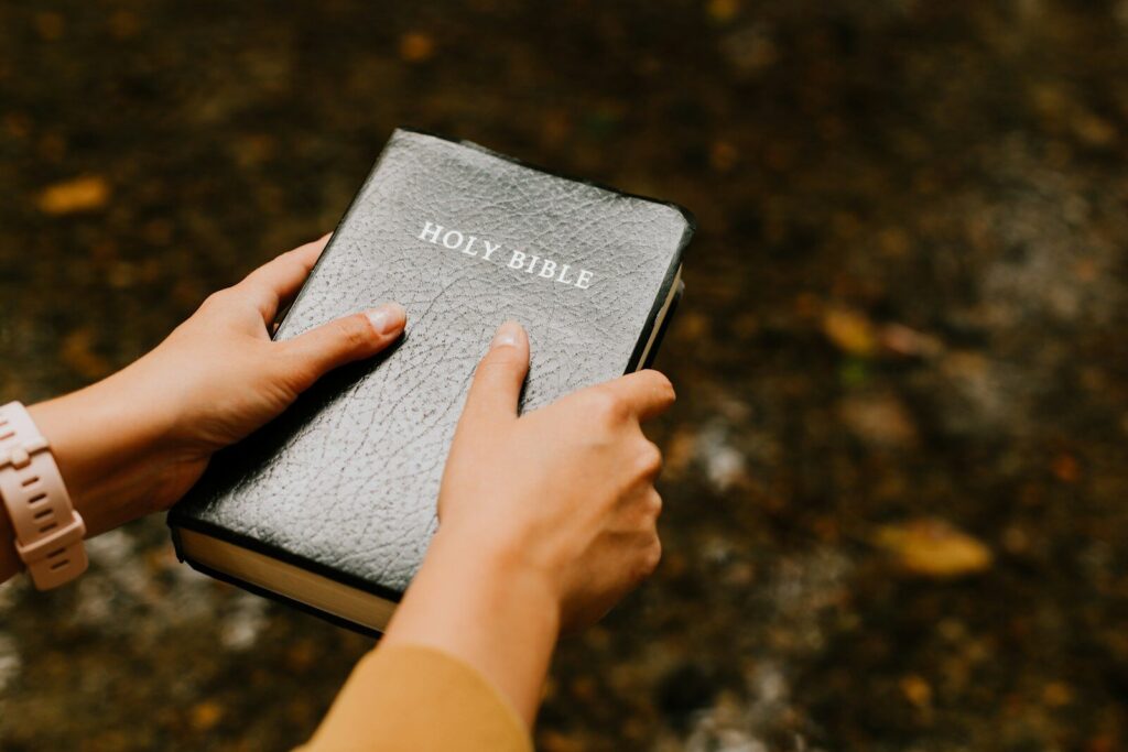 Person holding a copy of the Holy Bible